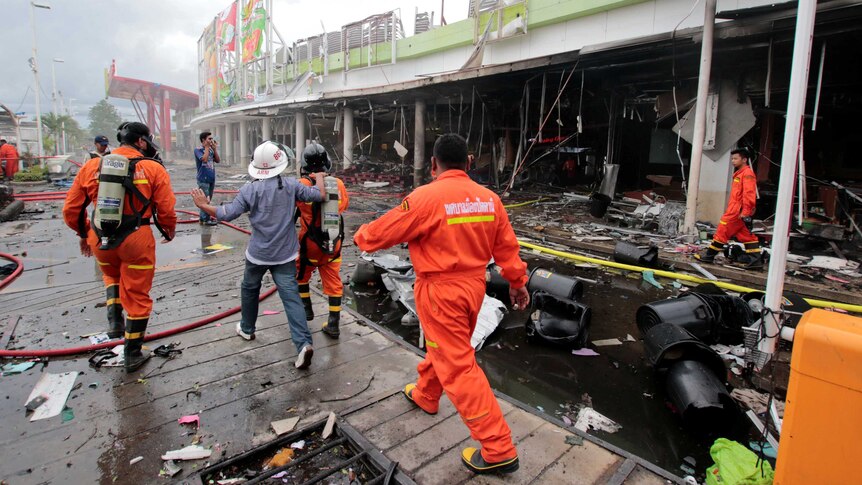 Rescue workers patrol a blast site outside a supermarket in Pattani, Thailand.