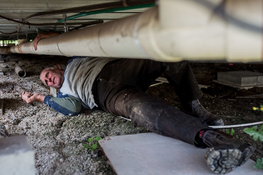 James on his back underneath his house.