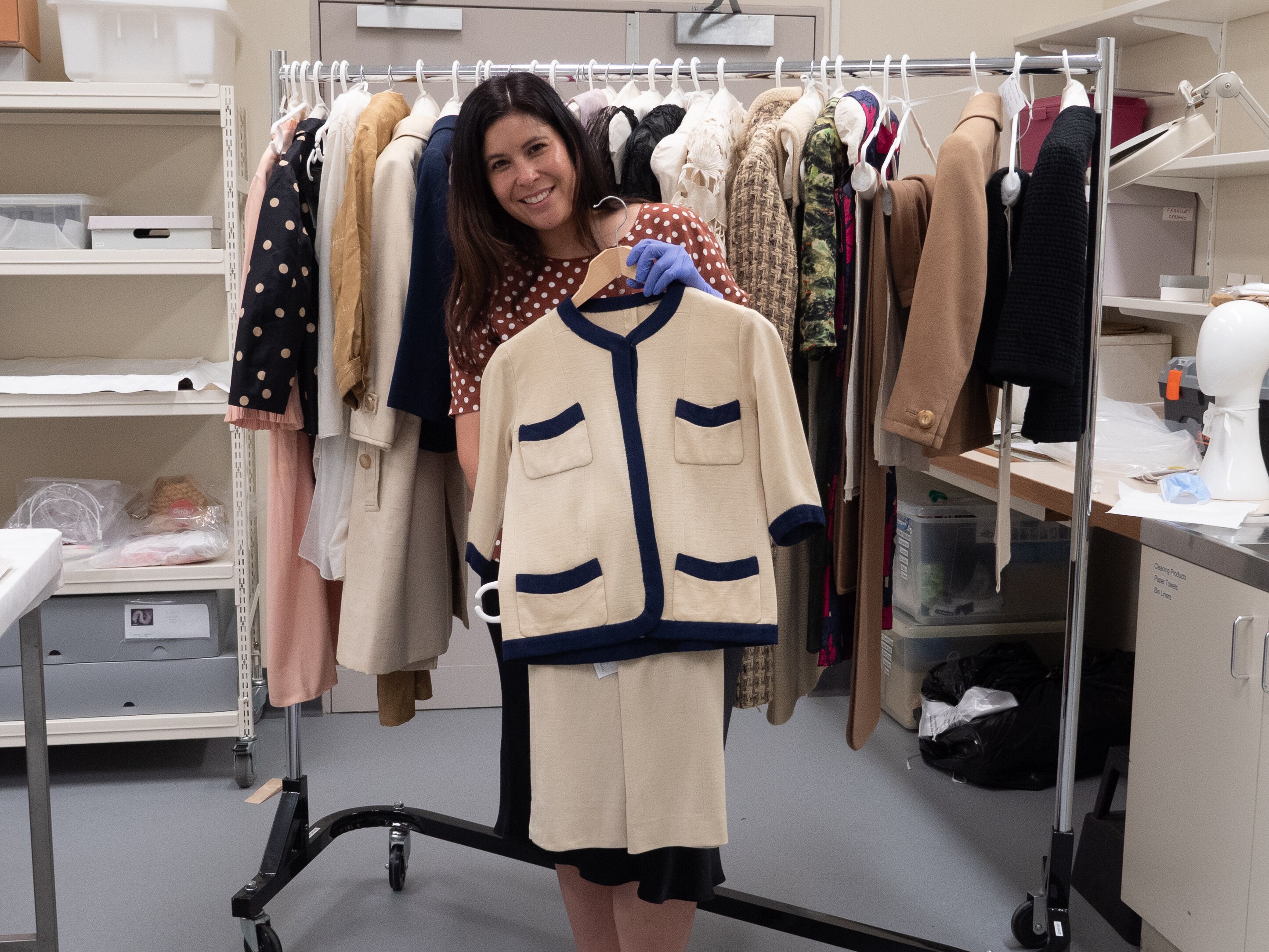 A woman holds a black and white suit.