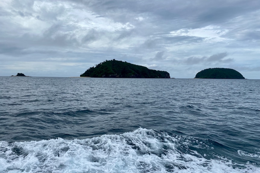 Two islands and a rock in the ocean, taken from a boat