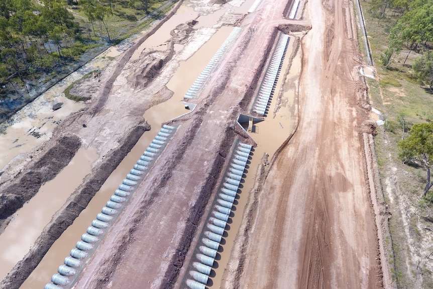 A rail line construction project, showing a series of pipes running under the rain line