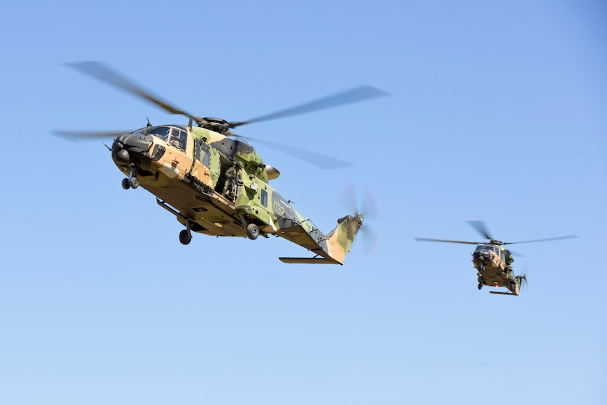 Two Australian Army MRH-90 Taipains in flight against a blue sky.