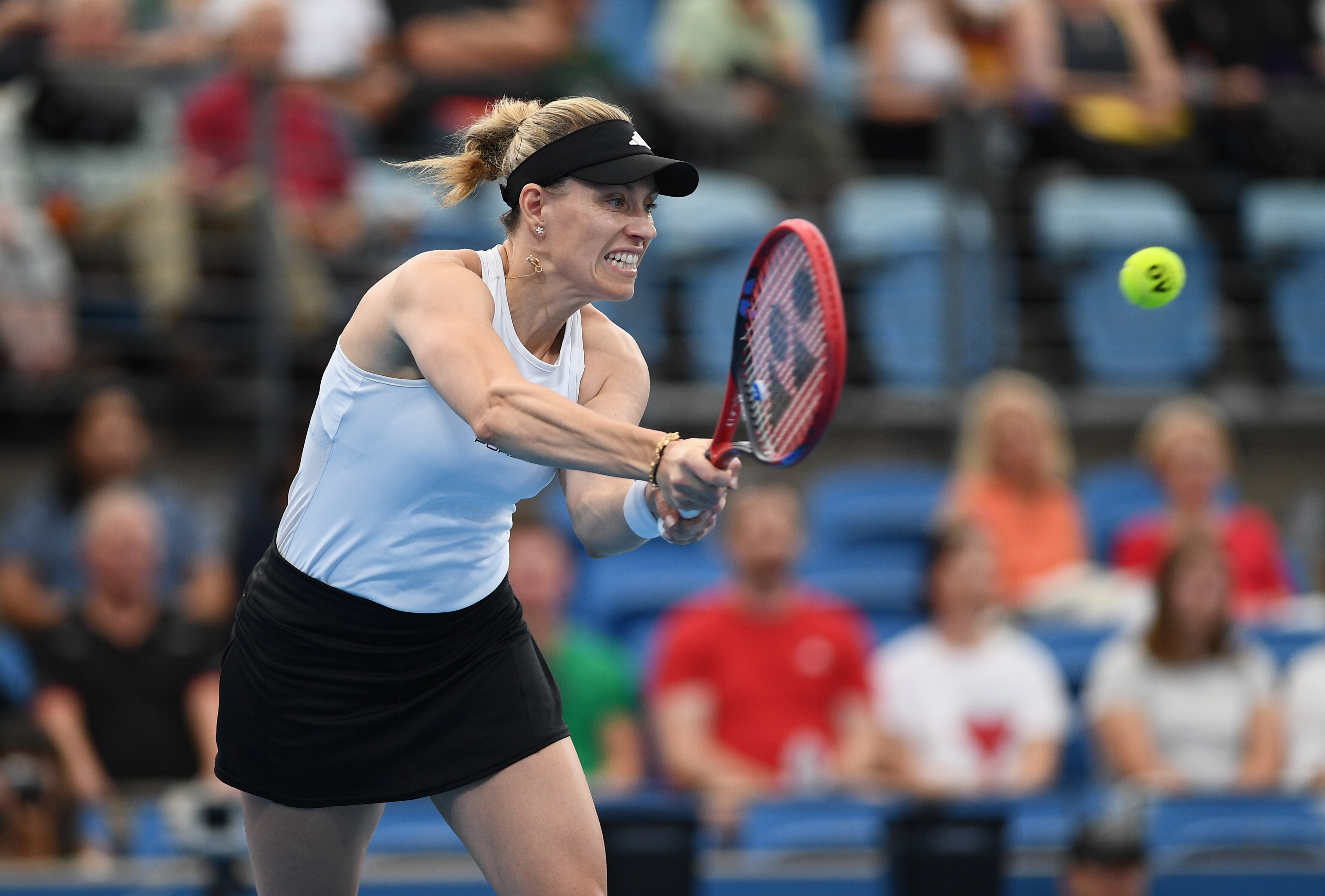 Angelique Kerber gritting her teeth as she hits a tennis ball. 