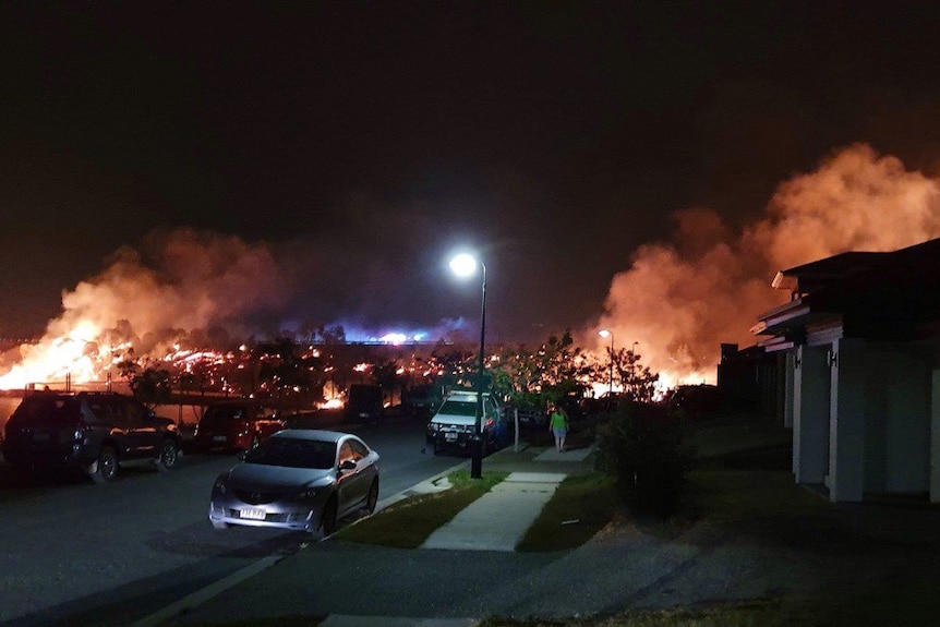 Flames burning in the distance close to homes along the Centenary Highway.