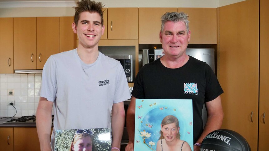 Ben (left) and Ian Myors posing with photos of Chloe in their kitchen.