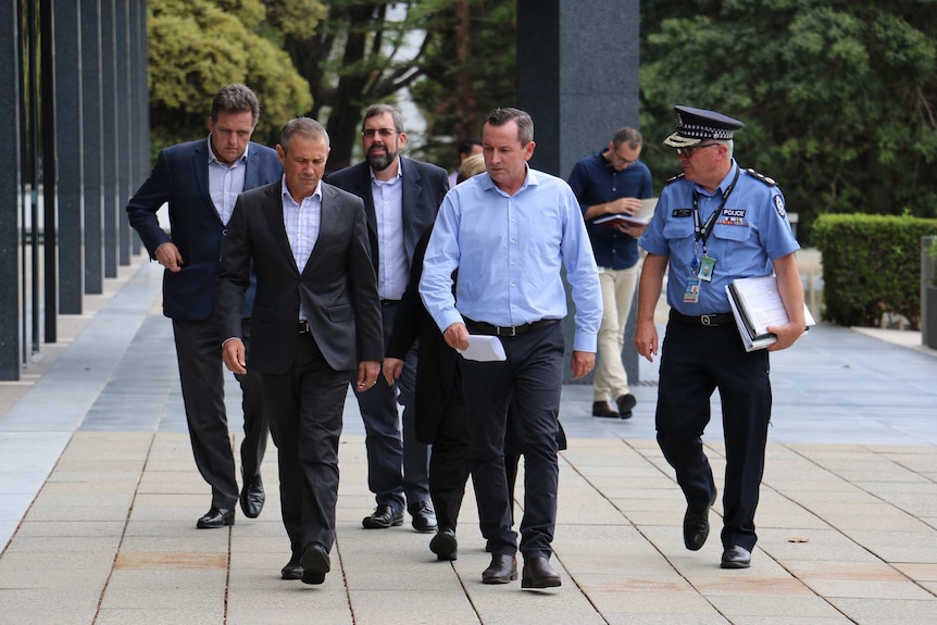 Premier Mark McGowan, Health Minister Roger Cook and WA Police Commissioner Chris Dawson walk at the front of a group outside.