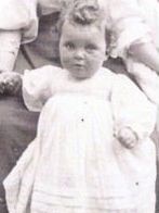 Black and white photo of baby in big white dress