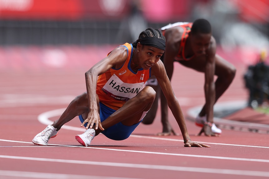 Two women getting up off the ground after tripping over during a 1,500m heat at the Olympics