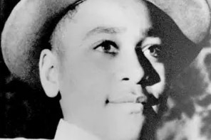 A young black boy wearing a hat and suit top and tie 