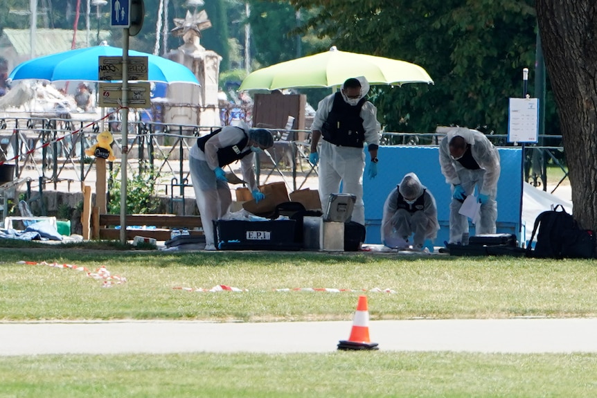 Police officers investigate at the scene after a knife attack