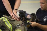 Two firefighters perform a CPR drill on their colleague