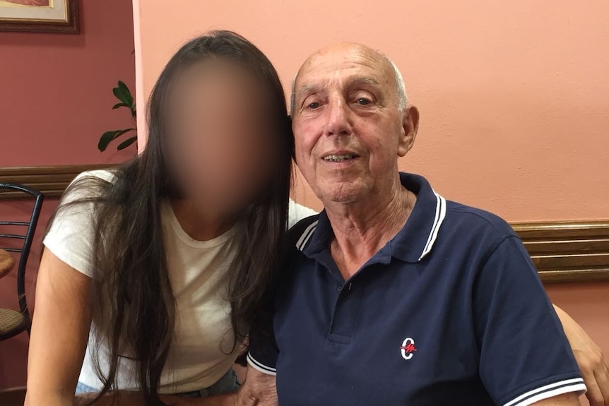 An older man next to a woman whose face is blurred.
