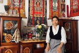 Tenzin Choeki sits in her apartment, which is an ode to the Dalai Lama.