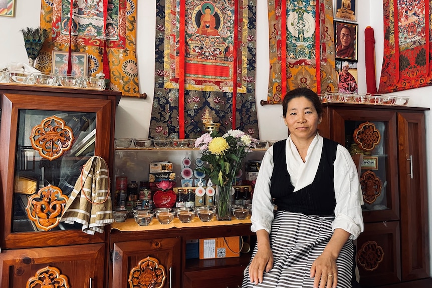 Tenzin Choeki sits in her apartment, which is an ode to the Dalai Lama.