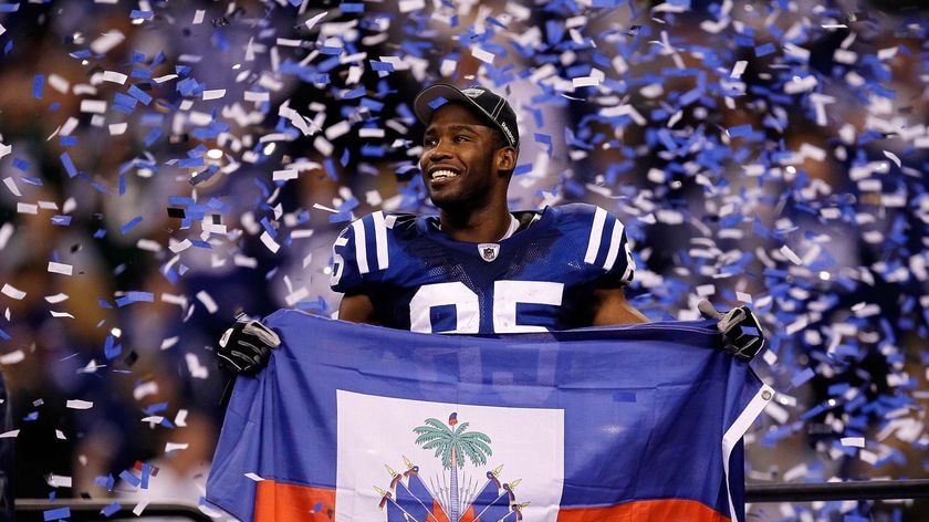 Pierre Garcon holds up a Haitian flag after the Colts defeated the New York Jets 30-17 during the AFC Championship Game.