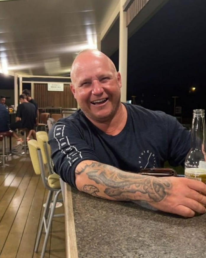 A smiling bald man in a pub.