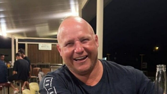 A smiling bald man in a pub.