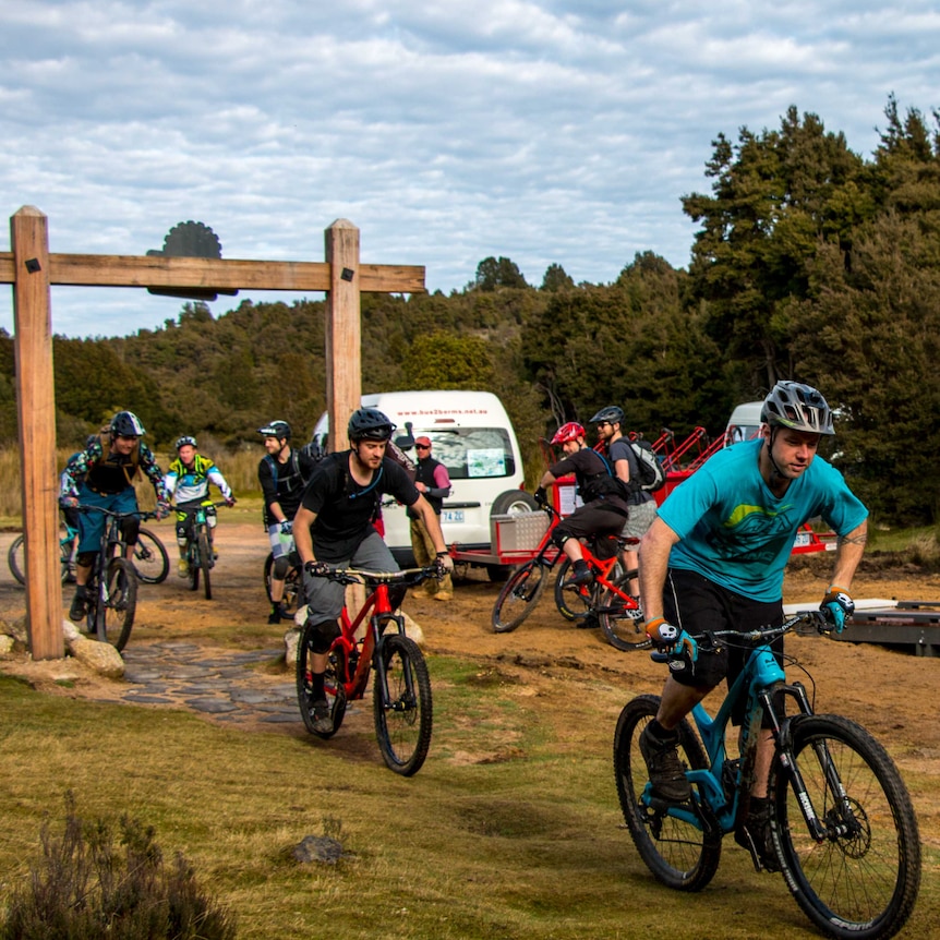 A group of mountain bikers riding through the start of one of Blue Derby's trails