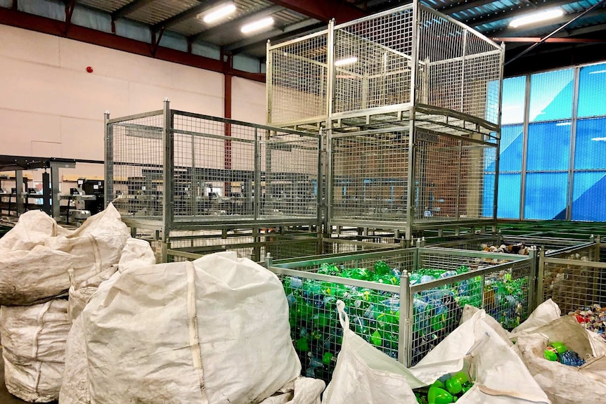 Container facility with sorted bottles in cages.