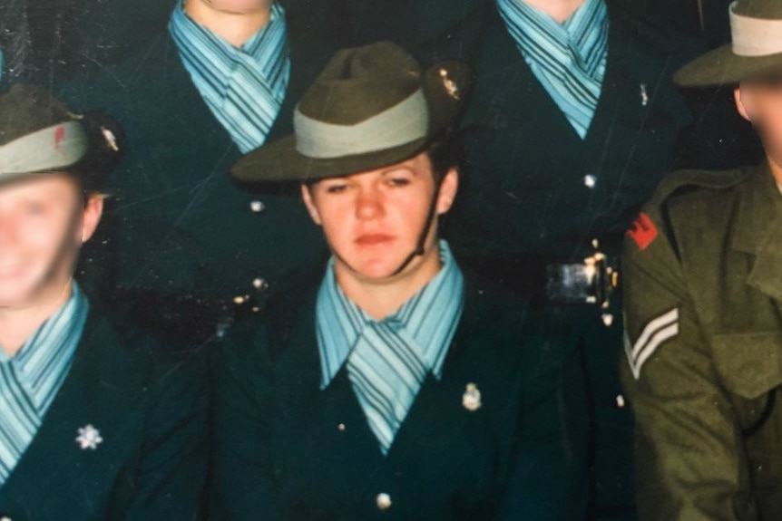 Jodi Ball standing in uniform in a row with other officers whose faces are blurred.