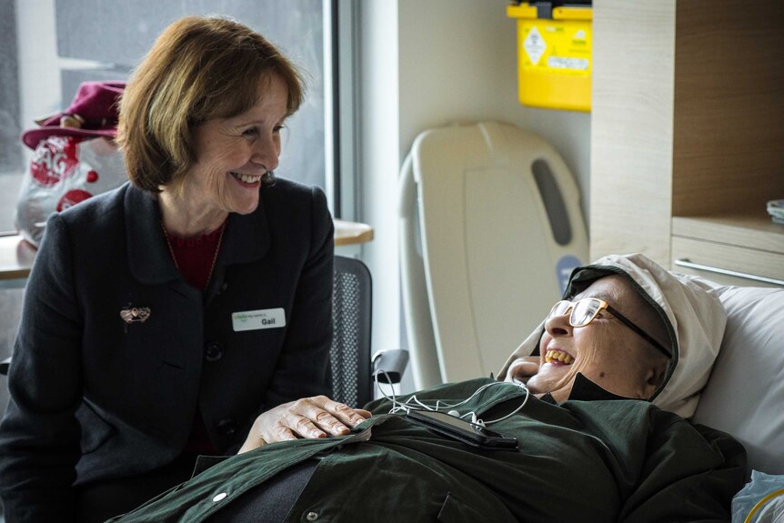 Patient Advocate Gail O'Brien and Rita Martin who has lung cancer smile at each other.