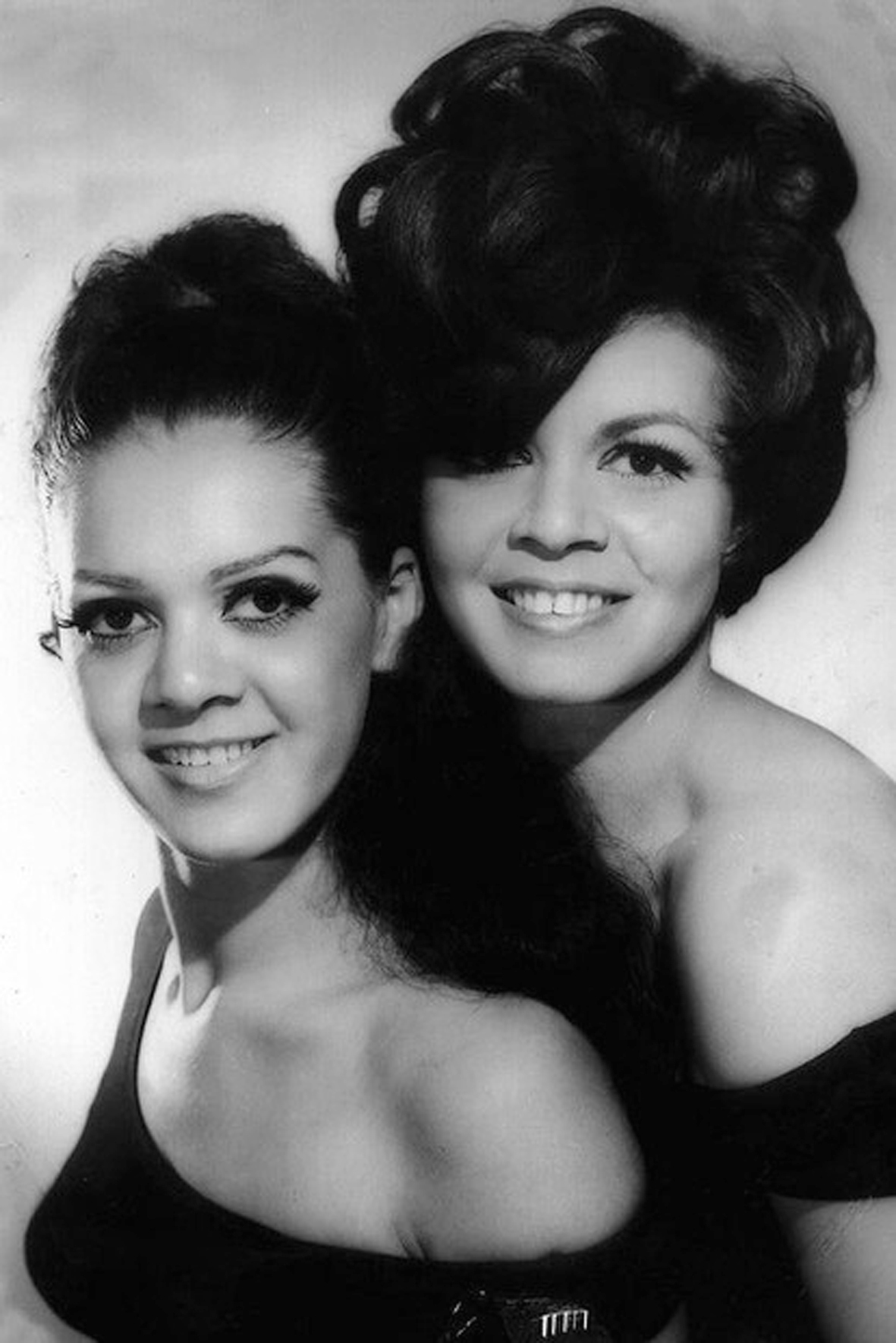 Black and white photo of two young women dressed up in beehive hair 