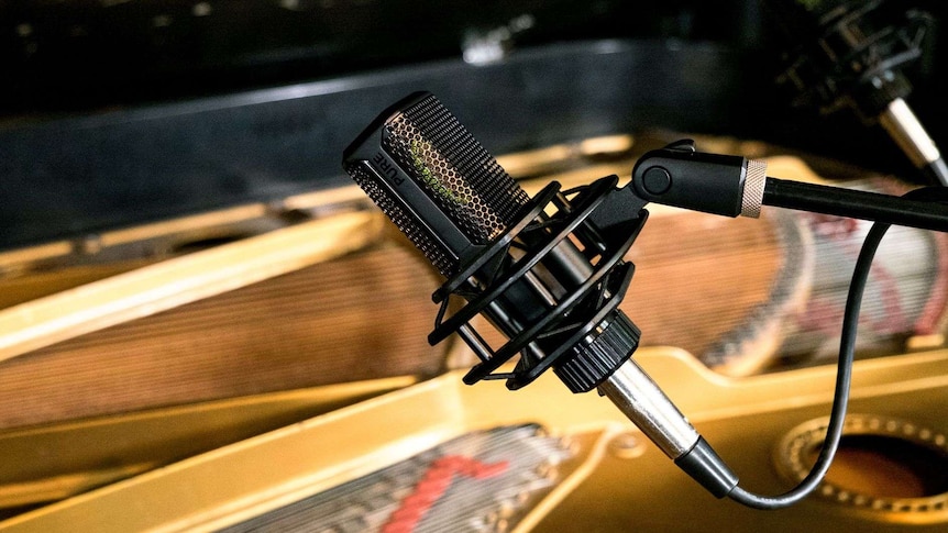A microphone sitting atop a piano