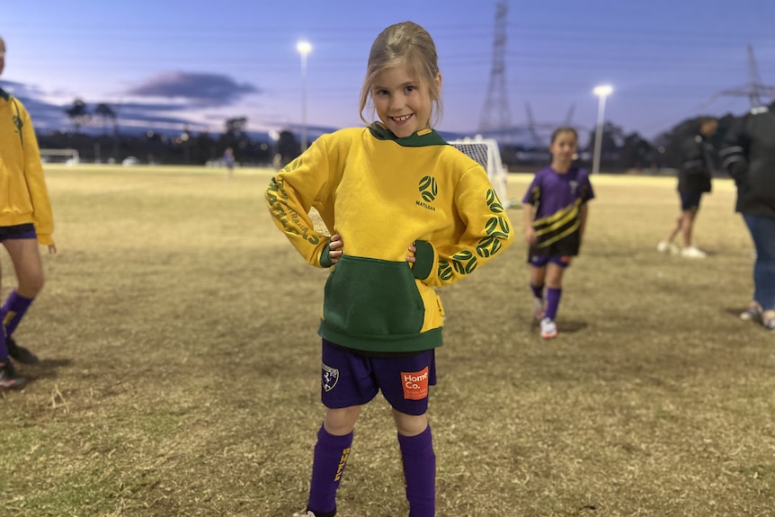 Young girl in a yellow Matildas jersey