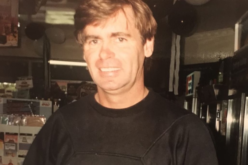 An old photo of a man wearing a black t-shirt