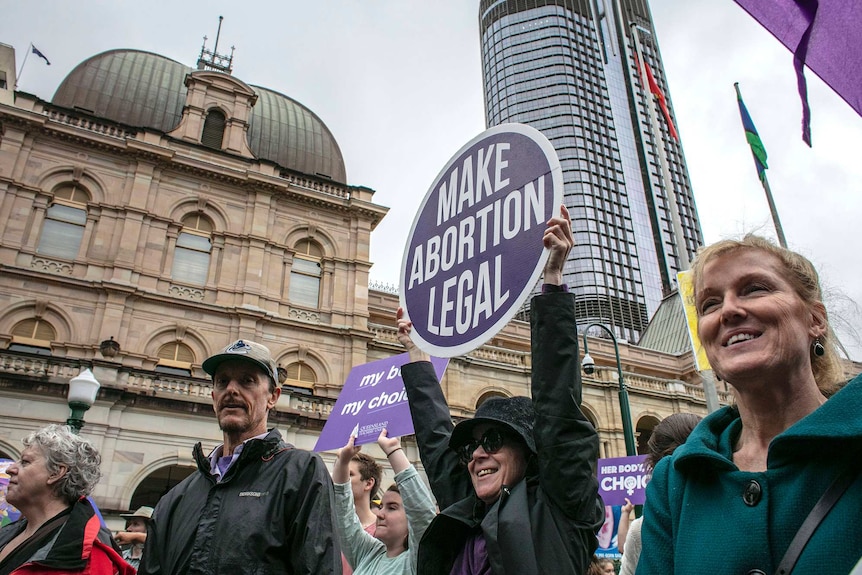 People are seen attending the March together for Choice rally in Brisbane.