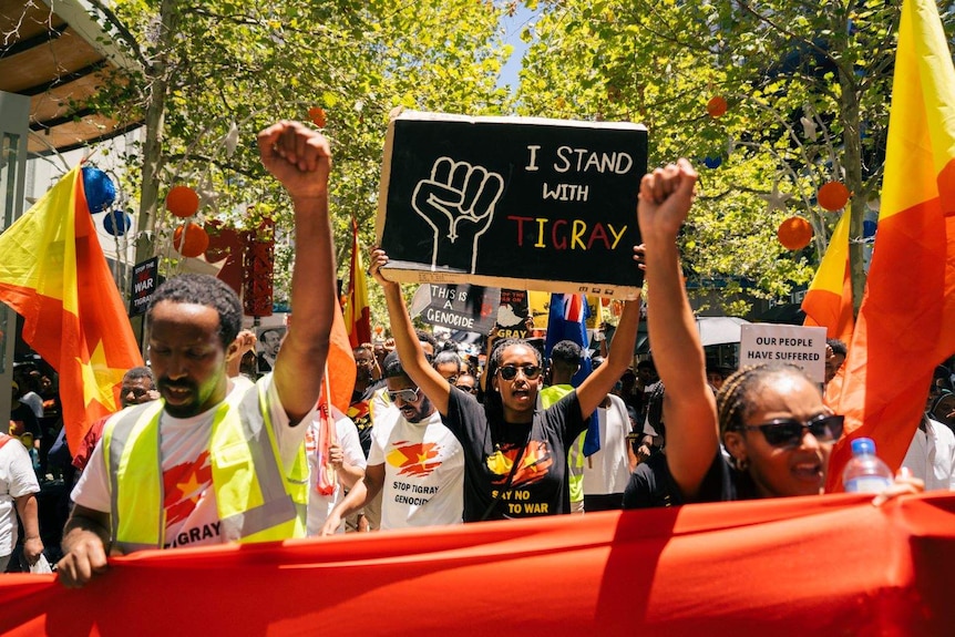 A protester holds a "I stand with Tigray" sign at a rally in Perth.
