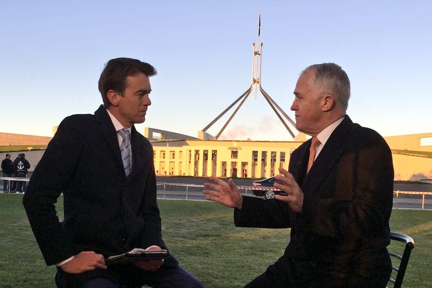 Rowland and Turnbull sitting on stools outside Parliament House in Canberra.