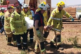 a team of firies carries someone on a stretcher