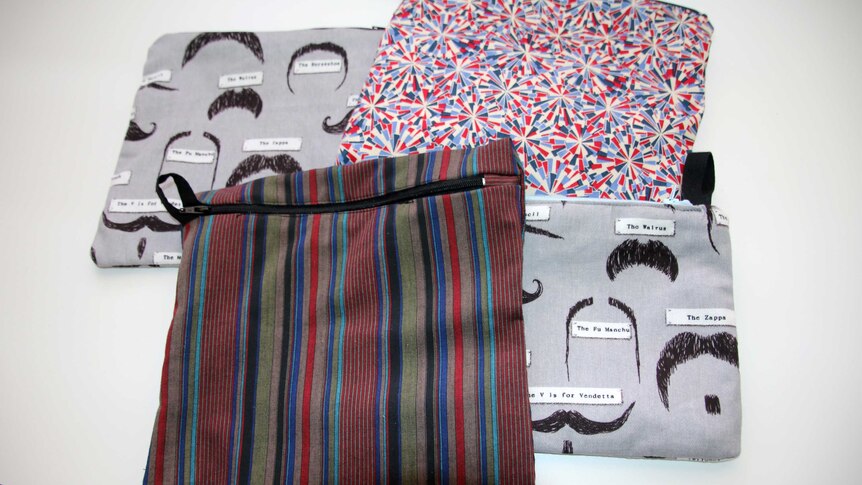 Four patterned cloth bags with zips for storing sanitary products.