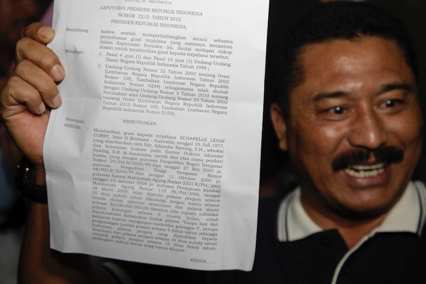 The head of Kerobokan prison holds up a piece of paper declaring clemency granted to Schapelle Corby.