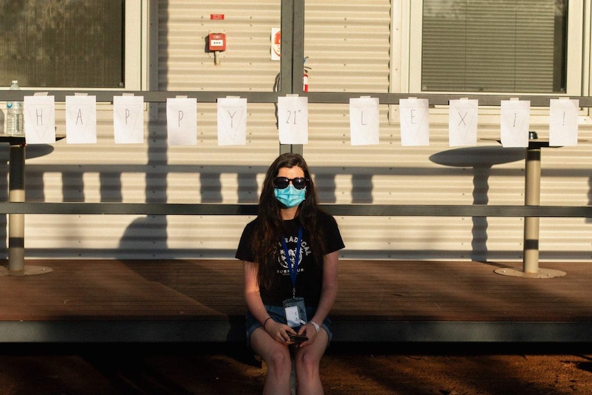 A photo of film student Lexi Spurr wearing a mask in quarantine at Howard Springs.