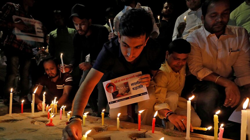 A man lights a candle during a vigil
