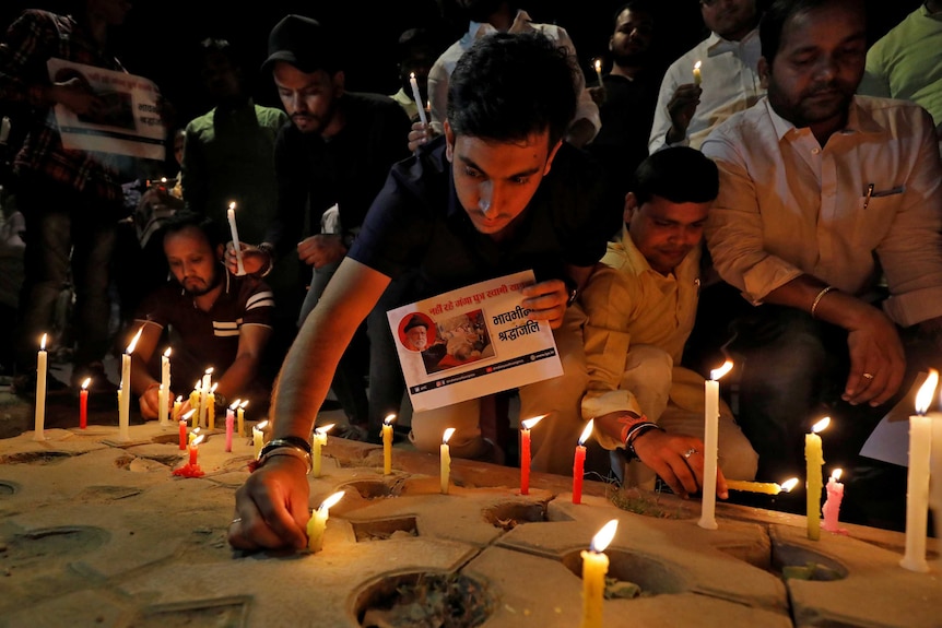 A man lights a candle during a vigil