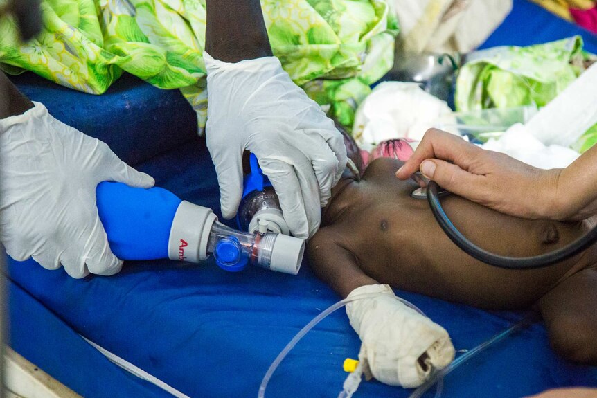 Medics work to revive baby Nyanene, who is not responding to treatment.