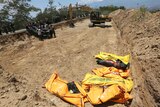 A mass burial of earthquake and tsunami victims is prepared in Palu.