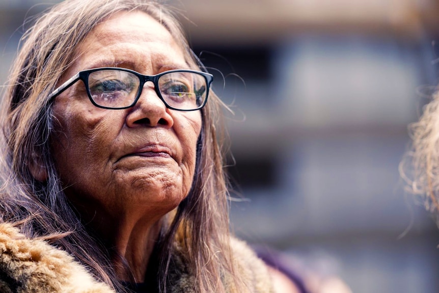 Aunty Donna Nelson, wearing glasses, stands outside the Coroners Court of Victoria.