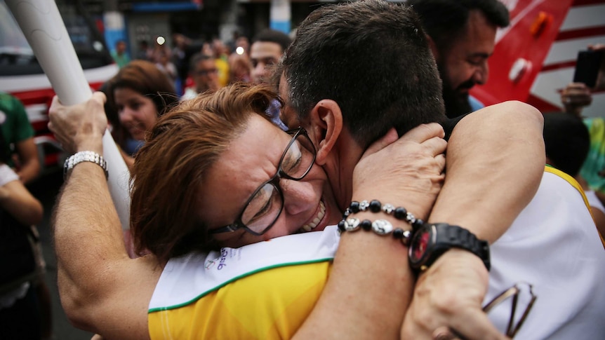 Supporter hugs Olympic torch bearer in Rio
