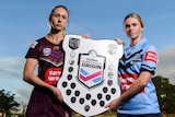 Karina Brown and Maddison Studdon pose for a photo holding the State of Origin shield together.
