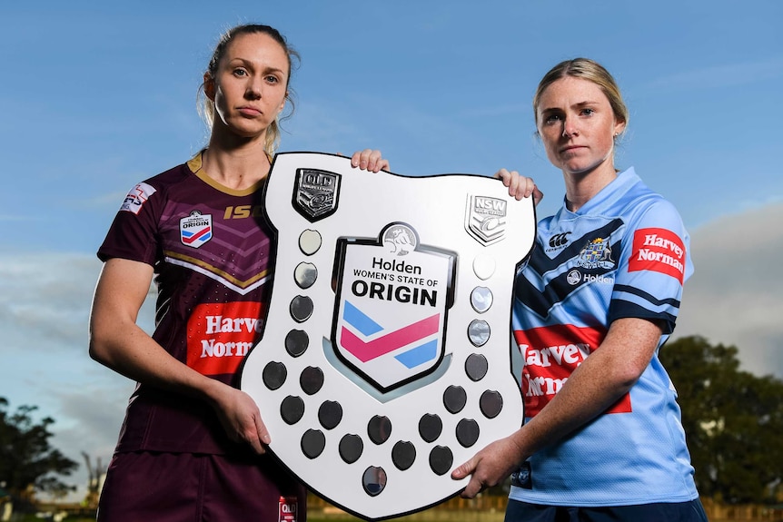 Karina Brown and Maddison Studdon pose for a photo holding the State of Origin shield together.