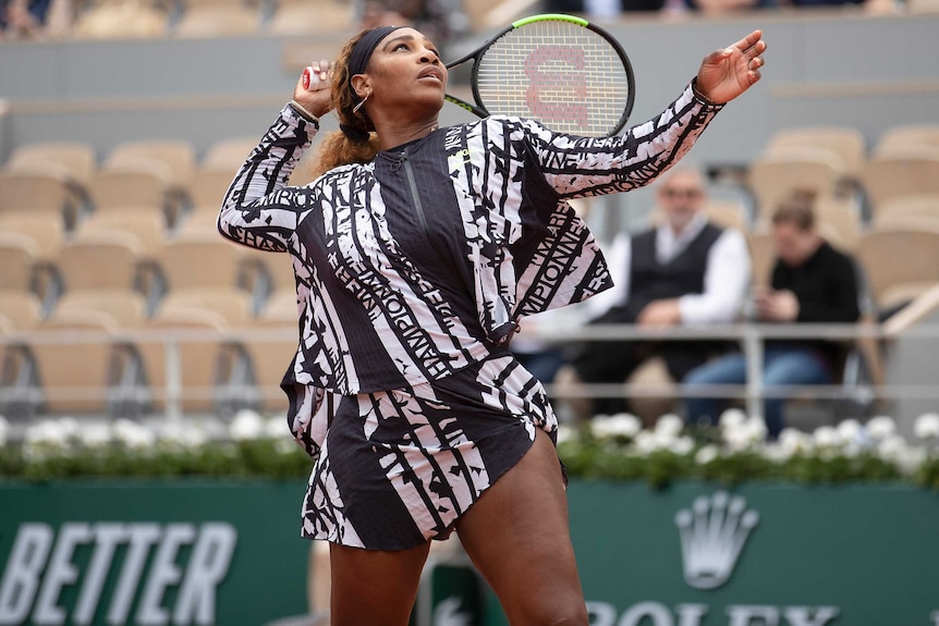 A tennis player warms up with a jacket on with words written on it in French.