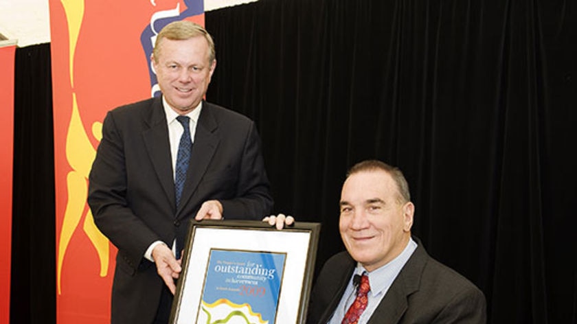 Former Footscray footballer Neil Sachse (right) accepts an award from SA Premier Mike Rann in 2009.