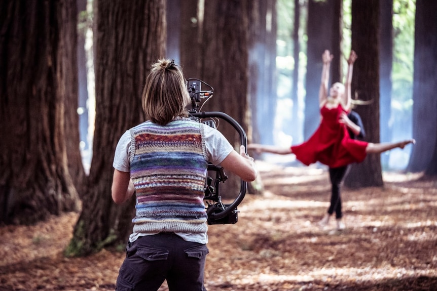 Cameraman films dancers in a forest for a short film
