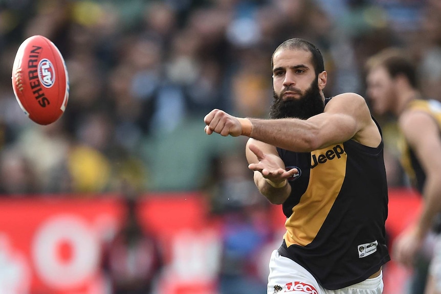 Richmond's Bachar Houli handballs against Collingwood during round 21 of the AFL at the MCG in Melbourne on August 22, 2015.