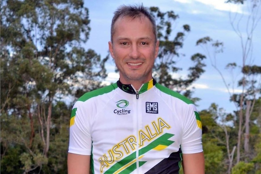 A man dressed in cycling lycra smiles at the camera.