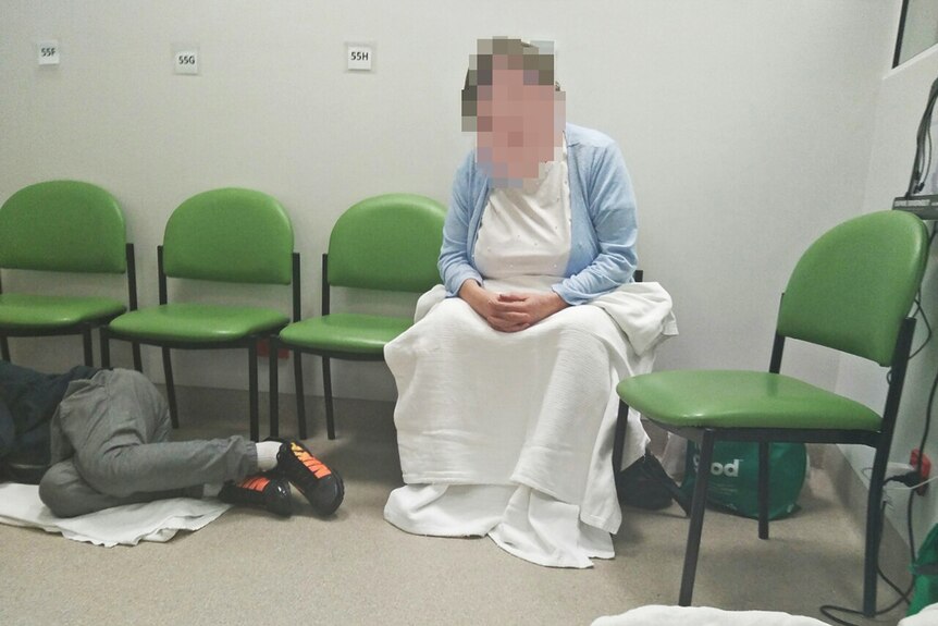 A woman sits while a man lies at Royal Hobart Hospital emergency department.